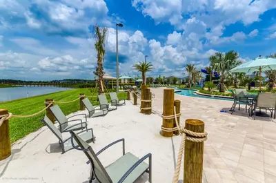 a group of chairs and tables next to a pool at 4814 Lullaby Lane in Kissimmee