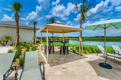 a patio with chairs and tables and umbrellas at 4814 Lullaby Lane in Kissimmee