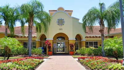 a building with palm trees and flowers at Beautiful Vista Cay Condo, Near I-Drive in Orlando