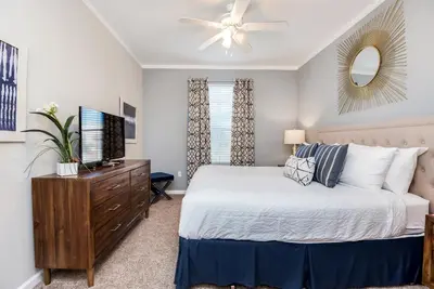 a bedroom with a bed and a dresser with a television at Beautiful Vista Cay Condo, Near I-Drive in Orlando