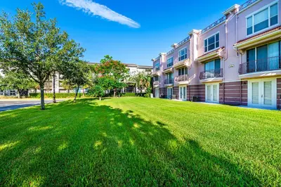 a large green lawn in front of a building at Updated Vista Cay Townhome, 10 min from Universal in Orlando