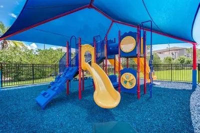 a playground with a slide in a park at Updated Vista Cay Townhome, 10 min from Universal in Orlando