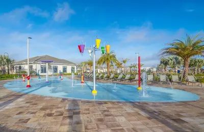 a pool with water fountains in a parking lot at 4833NF TOWNHOUSE 4 BEDROOMS & 3 BATHROOMS + POOL in Kissimmee