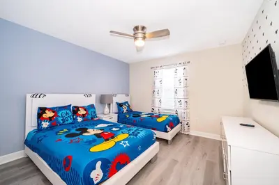 a bedroom with two beds and a flat screen tv at 4833NF TOWNHOUSE 4 BEDROOMS & 3 BATHROOMS + POOL in Kissimmee