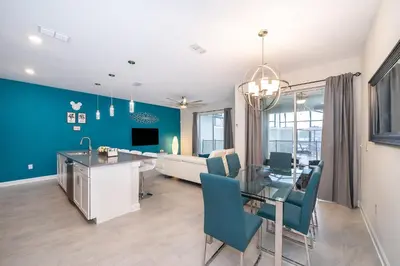 a dining room and living room with a dining table at 4830FA TOWNHOUSE 4 BEDROOMS & 3 BATHROOMS + POOL in Kissimmee