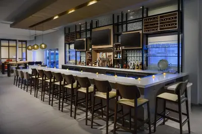 a bar with a row of stools in a room at Hilton Garden Inn Apopka City Center, Fl in Orlando