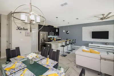 a dining room and kitchen with a table and a couch at 4929GC TOWNHOUSE 4 BEDROOMS & 3 BATHROOMS + POOL in Kissimmee