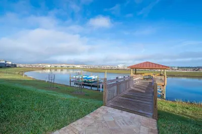 a dock with a gazebo and a boat on a lake at 4929GC TOWNHOUSE 4 BEDROOMS & 3 BATHROOMS + POOL in Kissimmee