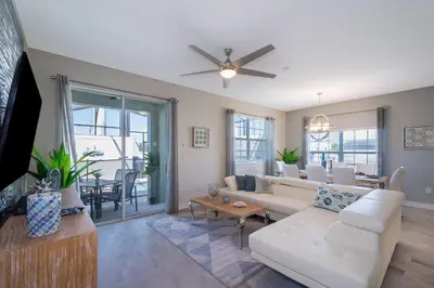 a living room with a white couch and a ceiling fan at 4975AN TOWNHOUSE 5 BEDROOMS & 4 BATHROOMS + POOL in Kissimmee
