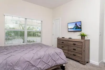 a bedroom with a bed and a television on a dresser at Luxurious Décor 4 Bd w/ Pool Close to Disney 4820 in Kissimmee