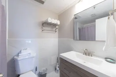 a bathroom with a sink and a toilet and a mirror at Deluxe Studio w/ Lakeview - free parking/pool in Orlando