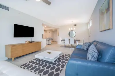 a living room with a blue couch and a flat screen tv at 4721-101FG STOREY LAKE, CONDO 3/2 GARDEN VIEW in Kissimmee