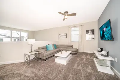 a living room with a couch and a ceiling fan at 2770AG VILLA 5 BED/5 BA (SANITIZED) in Kissimmee