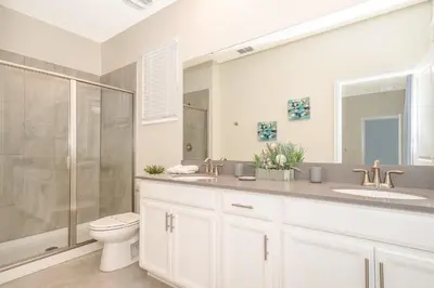 a bathroom with a toilet and a sink and a shower at 2770AG VILLA 5 BED/5 BA (SANITIZED) in Kissimmee