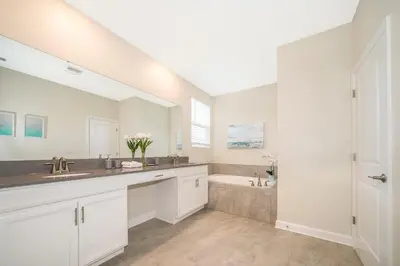 a white bathroom with two sinks and a tub at 2770AG VILLA 5 BED/5 BA (SANITIZED) in Kissimmee