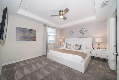 a white bedroom with a bed and a ceiling fan at 3120-201BB STOREY LAKE, CONDO 3/2 GARDEN VIEW in Kissimmee