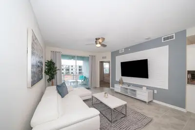 a living room with a white couch and a tv at 3120-201BB STOREY LAKE, CONDO 3/2 GARDEN VIEW in Kissimmee