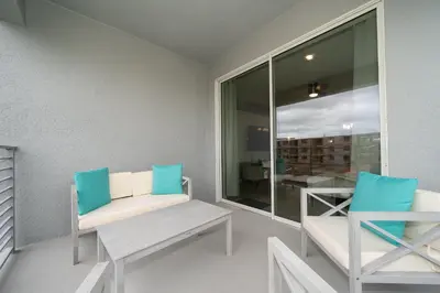 a balcony with two chairs and a bench and a window at 3120-201BB STOREY LAKE, CONDO 3/2 GARDEN VIEW in Kissimmee