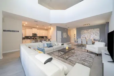 a living room with a white couch and a table at 2738WE VILLA 5 BED/5 BA (SANITIZED) in Kissimmee