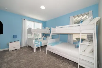 a bedroom with two bunk beds and blue walls at 2738WE VILLA 5 BED/5 BA (SANITIZED) in Kissimmee