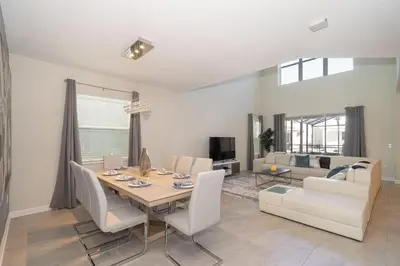 a dining room and living room with a table and chairs at 2738WE VILLA 5 BED/5 BA (SANITIZED) in Kissimmee
