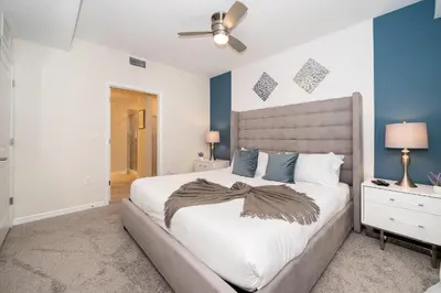 a bedroom with a large bed and blue walls at 3120-206DR STOREY LAKE, CONDO 2/2 GARDEN VIEW in Kissimmee