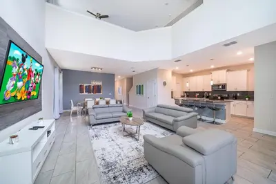 a large living room with couches and a flat screen tv at 2731EE VILLA 5 BED/5 BA (SANITIZED) in Kissimmee