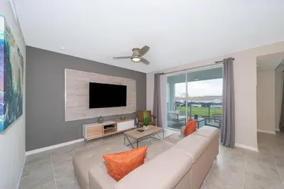 a living room with a couch and a flat screen tv at 3111-302HM STOREY LAKE, CONDO 2/2 LAKE VIEW in Kissimmee