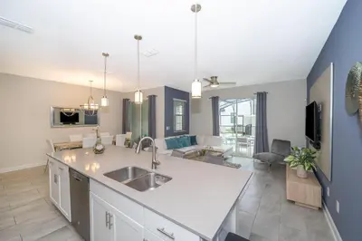 a kitchen with a sink and a living room at 4964RS TOWNHOUSE 4 BEDROOMS & 3 BATHROOMS + POOL in Kissimmee