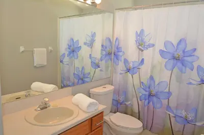 a bathroom with a sink and a shower curtain with blue flowers at 2685OL - Jagu Deaux (G) in Kissimmee