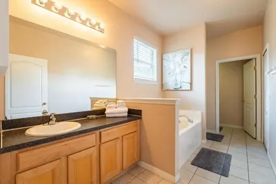 a bathroom with a sink and a mirror and a tub at 1323ZUREIQ-Zureiq Dreams (S) in Orlando