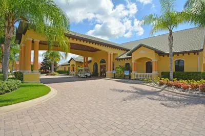 a yellow house with palm trees and a driveway at 8975CPR - Waites Home (G) in Kissimmee