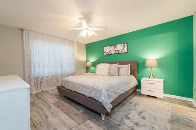 a green bedroom with a bed and a green wall at VOS-2739PB-73 - Somerset Gardens (S) in Kissimmee