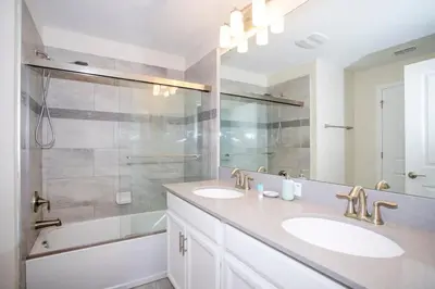 a white bathroom with two sinks and a shower at Ravishing Four Bd w/ Pool Close to Disney 4947 in Kissimmee