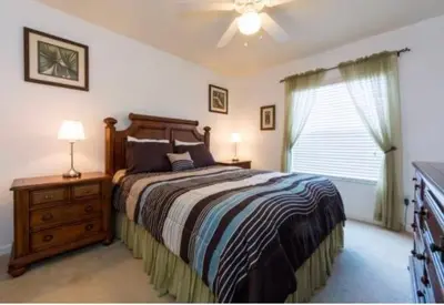 a bedroom with a bed and a dresser and a window at Encantada 3 Bedroom Townhome with Pool 2009 in Kissimmee