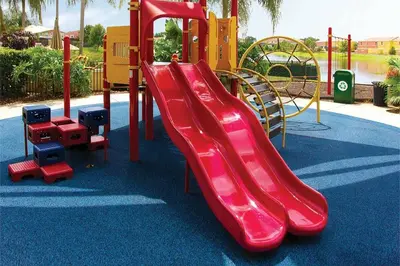 a red slide on a playground in a park at Encantada 3 Bedroom Townhome with Pool 2009 in Kissimmee