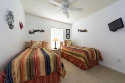a bedroom with two beds and a ceiling fan at Encantada 3 Bedroom Townhome with Pool 2009 in Kissimmee