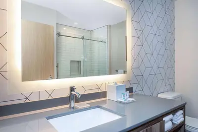 a bathroom with a sink and a mirror at TRYP by Wyndham Orlando in Orlando
