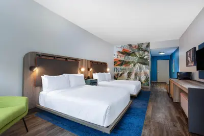 a hotel room with two beds and a television at TRYP by Wyndham Orlando in Orlando