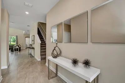 a living room with a white table and a staircase at Storey Lake Resort 5 Bedroom Vacation Home with Pool 2307 in Kissimmee