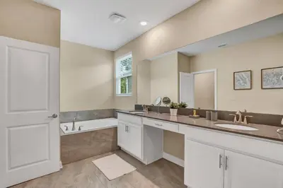 a bathroom with two sinks and a tub and a mirror at Storey Lake Resort 5 Bedroom Vacation Home with Pool 2307 in Kissimmee