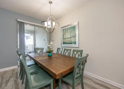 a dining room with a wooden table and chairs at 4907JA TOWNHOUSE 4 BEDROOMS & 3 BATHROOMS + POOL in Kissimmee