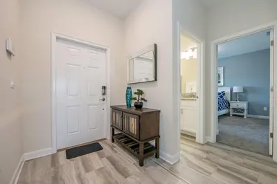 a hallway with a white door and a table at 4907JA TOWNHOUSE 4 BEDROOMS & 3 BATHROOMS + POOL in Kissimmee