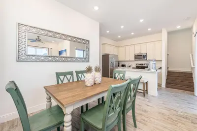 a kitchen and dining room with a wooden table and chairs at Fabulous Cottage Near Disney With Margaritaville Resort & Island H2O Access - 8075Kd in Orlando