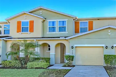 a house with a garage in front of it at 4 Bedroom SunHaven Townhouse with Pool Near Disney in Kissimmee