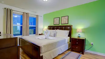 a bedroom with a bed with a dresser and a window at 4 Bedroom SunHaven Townhouse with Pool Near Disney in Kissimmee