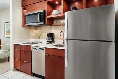 a kitchen with a refrigerator and a sink at TownePlace Suites by Marriott Orlando Downtown in Orlando