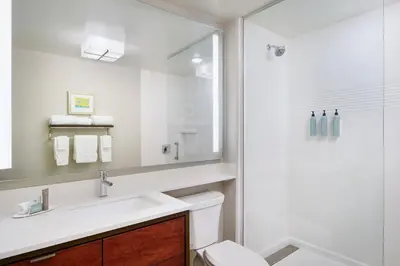 a white bathroom with a sink and a shower at TownePlace Suites by Marriott Orlando Downtown in Orlando