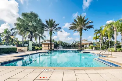 a swimming pool with palm trees in the background at 2 Bedroom Vacation Condo 2011 in Kissimmee