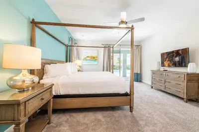a bedroom with a bed and a table with a lamp at Vibrant Home With Private Pool, Pool Table Near Disney With Waterpark & Resort Access At Encore Resort - 7707Gr in Kissimmee
